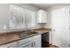 White kitchen with granite countertops and sink at 42999 W Samuel Dr, Maricopa, AZ 85138