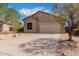 Tan house with two-car garage and desert landscaping at 6599 E Casa De Leon Ln, Gold Canyon, AZ 85118