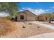 Tan house with two-car garage and desert landscaping at 6599 E Casa De Leon Ln, Gold Canyon, AZ 85118