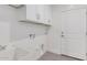 Functional laundry room with white cabinets and utility sink at 35075 N Palm Dr, San Tan Valley, AZ 85140