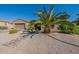 One-story house with a desert landscape and palm trees at 20340 N Canyon Whisper Dr, Surprise, AZ 85387