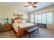 Main bedroom with bay window, wooden furniture, and ceiling fan at 20340 N Canyon Whisper Dr, Surprise, AZ 85387