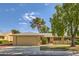 Tan house exterior with a two car garage and landscaping at 13605 N Redwood Dr, Sun City, AZ 85351