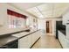 Kitchen with white cabinets, double sink, and view into dining area at 13605 N Redwood Dr, Sun City, AZ 85351