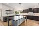 Spacious kitchen featuring a large island and dark wood cabinets at 7329 N 173Rd Ave, Waddell, AZ 85355