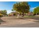 House with a large tree in front, tan stucco with stone accents at 7642 N 177Th Ave, Waddell, AZ 85355