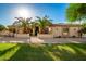 Tan stucco house with stone accents and palm trees in front at 7642 N 177Th Ave, Waddell, AZ 85355