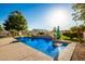 Relaxing backyard pool with a waterfall feature and basketball hoop at 7642 N 177Th Ave, Waddell, AZ 85355