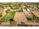 Aerial view of a sand riding arena with round pen, and a house in the background at 7642 N 177Th Ave, Waddell, AZ 85355