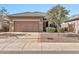 Tan two-car garage home with a manicured front yard at 40708 N Apollo Way, Anthem, AZ 85086