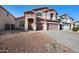 Two-story home with taupe exterior, two-car garage, and desert landscaping at 46024 W Amsterdam Rd, Maricopa, AZ 85139