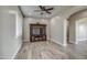Living room with wood-look floors, ceiling fan, and built-in entertainment center at 29923 W Melvin St, Buckeye, AZ 85396