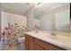 Bathroom boasts double sinks and a floral shower curtain at 18516 W Sweet Acacia Dr, Goodyear, AZ 85338