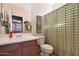 Bathroom with shower/tub combo, wood vanity, and checkered curtain at 18516 W Sweet Acacia Dr, Goodyear, AZ 85338
