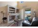 Gathering room with fireplace, built-in shelves and patio access at 18516 W Sweet Acacia Dr, Goodyear, AZ 85338