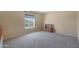 Bright bedroom with neutral carpeting and a large window at 18516 W Sweet Acacia Dr, Goodyear, AZ 85338