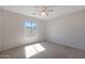 Well-lit bedroom featuring a ceiling fan and neutral carpeting at 18516 W Sweet Acacia Dr, Goodyear, AZ 85338