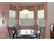 Charming dining area with glass-top table and window seating at 18516 W Sweet Acacia Dr, Goodyear, AZ 85338