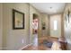 Bright entryway with tile flooring, bench, and view to the kitchen at 18516 W Sweet Acacia Dr, Goodyear, AZ 85338