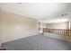 Spacious loft area with neutral carpeting and wood railing at 18516 W Sweet Acacia Dr, Goodyear, AZ 85338