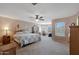 Spacious primary bedroom with large windows and ceiling fan at 18516 W Sweet Acacia Dr, Goodyear, AZ 85338
