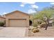 Tan colored stucco home with a two car garage and desert landscaping at 33556 N 74Th St, Scottsdale, AZ 85266