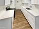 Modern kitchen with white cabinets, quartz countertops, and wood-look floors at 4322 N 50Th Dr, Phoenix, AZ 85031
