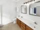 Clean bathroom with dual sinks, a toilet and a large mirror at 11575 W Buchanan St, Avondale, AZ 85323