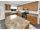 Modern kitchen featuring wood cabinets, stainless steel appliances, and an island at 11575 W Buchanan St, Avondale, AZ 85323