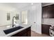 Kitchen island with sink, dark cabinetry, and view into adjacent living area at 16173 S 181St Ave, Goodyear, AZ 85338
