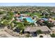 Aerial view of a community pool with a waterslide, shaded areas, and a playground at 2684 E San Miguel Dr, Casa Grande, AZ 85194