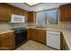 Kitchen with wood cabinets, appliances, and tile floor at 9856 W Rimrock Dr, Peoria, AZ 85382