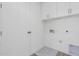 Convenient laundry room with upper cabinets and a built-in drain at 10223 E Ulysses Ave, Mesa, AZ 85212