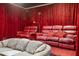 Home theater with red leather seating and dark red velvet curtains at 15972 N 115Th Way, Scottsdale, AZ 85255