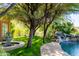 Serene pool and spa area with lush landscaping and a waterfall feature at 15972 N 115Th Way, Scottsdale, AZ 85255