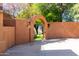 Elegant archway entrance leads to a beautifully landscaped backyard area at 15972 N 115Th Way, Scottsdale, AZ 85255