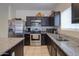 Modern kitchen with stainless steel appliances and granite countertops at 17078 N Rosemont St, Maricopa, AZ 85138