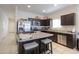 Modern kitchen featuring granite countertops, stainless steel appliances, and dark wood cabinets at 17078 N Rosemont St, Maricopa, AZ 85138