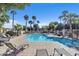 Community pool with lounge chairs and palm trees at 10030 W Indian School Rd # 218, Phoenix, AZ 85037