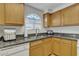 Kitchen with wood cabinets, granite countertops, and a double sink at 10030 W Indian School Rd # 218, Phoenix, AZ 85037
