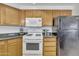 Well-equipped kitchen with gas stove, microwave and refrigerator at 10030 W Indian School Rd # 218, Phoenix, AZ 85037