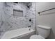 Clean bathroom with marble tile shower, tub, and toilet at 4950 N Miller Rd # 233, Scottsdale, AZ 85251