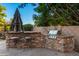 Built-in outdoor kitchen with grill and seating at 1367 E Desert Flower Ln, Phoenix, AZ 85048