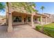 Covered patio with brick pavers, lush landscaping, and access to the backyard at 1367 E Desert Flower Ln, Phoenix, AZ 85048