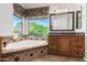 Bathroom with corner bathtub, wood cabinets, and large window at 1367 E Desert Flower Ln, Phoenix, AZ 85048