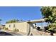 Tan mobile home with carport and desert landscaping at 9427 E University Dr # 100, Mesa, AZ 85207