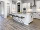 Modern kitchen with white cabinets, granite island, and stainless steel appliances at 15922 W Electra Ln, Surprise, AZ 85379