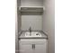 Laundry room with white cabinets, utility sink, and a drying rack at 15922 W Electra Ln, Surprise, AZ 85379