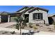 One-story home with gray siding, stone accents, and landscaping at 15922 W Electra Ln, Surprise, AZ 85379