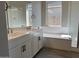 Bathroom with double vanity, soaking tub, and glass shower at 15922 W Electra Ln, Surprise, AZ 85379